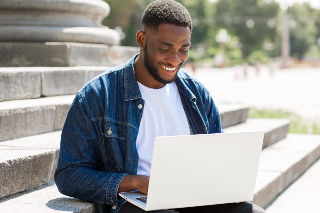 Young professional using a laptop in a public space, reflecting how digital innovation is reshaping the generational gap